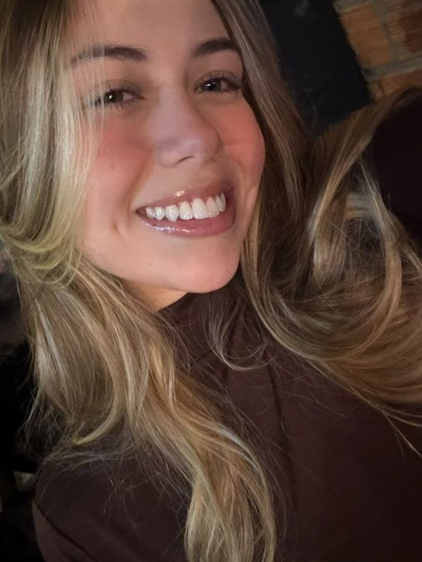 Vitória, da recepção, sorrindo
